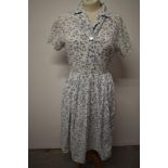 A 1950s abstract bubble pattern cotton day dress, having pleated skirt, buttons to front and side
