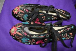 A pair of Chinese silk slippers with bright floral embroidery.