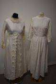 Two vintage wedding dresses, one having appliqué flowers and feather collar.