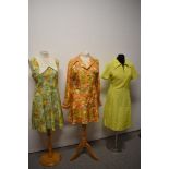 Three bright and cheerful 1960s mini dresses, including two with vibrant floral patterns.