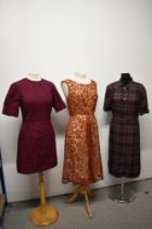 Three vintage 1950s to 1960s dresses, including plaid cotton in a larger size, with belt.