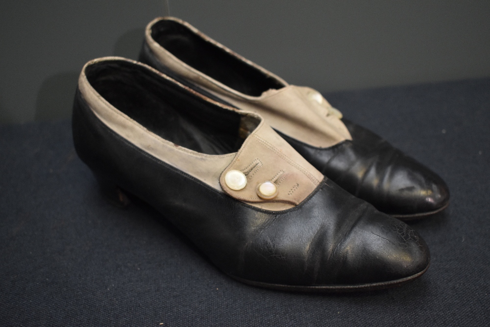 A pair of early 20th century black leather and cream suede shoes, having button decoration and stack