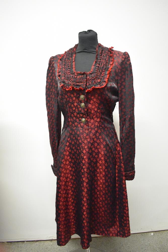 A 1940s red and black satin dirndl style dress, having buttons to front and side metal zip.