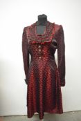 A 1940s red and black satin dirndl style dress, having buttons to front and side metal zip.