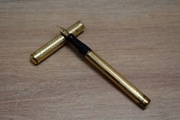 A Mabie Todd Self Filling lever fill fountain pen in yellow metal in engine turned chequered