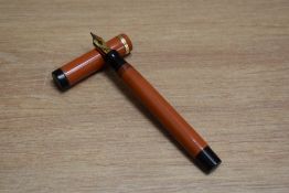 A Parker Duofold Lucky Curve Senior button fill fountain pen in orange with raised band to the cap