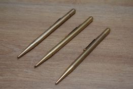 Three Mabie Todd Fyne Poynt propelling pencils in yellow metal having various engine turned designs