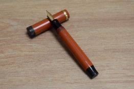 A Parker Duofold Junior Lucky Curve button fill fountain pen in orange with raised band to the cap