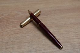 A Parker 65 aero fill fountain pen in burgundy with rolled gold cap having Parker 14k nib