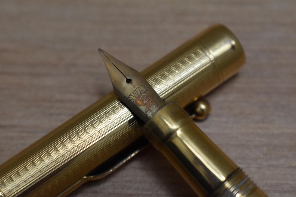 A Mabie Todd Self Filling lever fill fountain pen in yellow metal in engine turned wave design - Image 2 of 3
