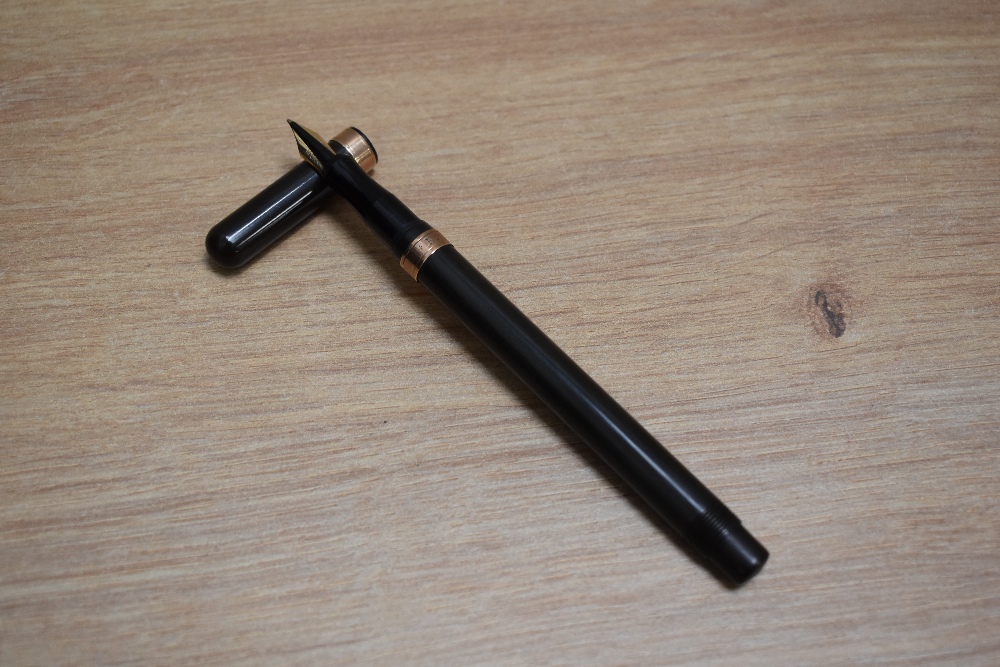 A De La Rue Onoto plunger fill fountain pen in BHR with gold band to the base of the cap and one