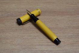 A Parker Duofold Junior Lucky Curve button fill fountain pen in mandarin yellow with two narrow