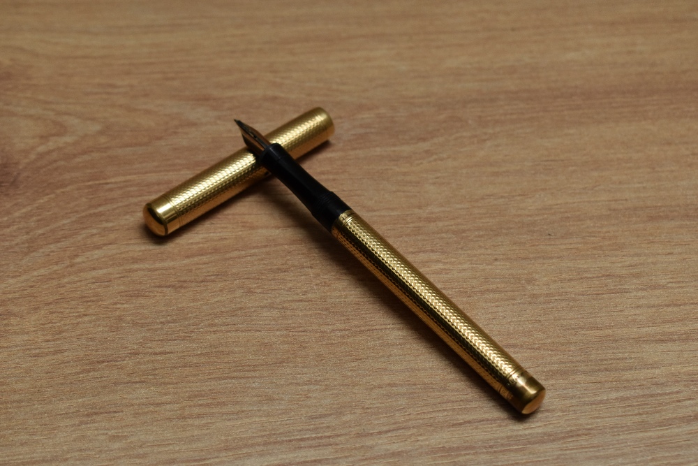 A Mabie Todd & Co Swan 2 eye dropper fountain pen in engine turned yellow metal having Mabie