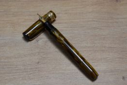 A Mabie Todd & Co Swan Visofil fountain pen in brown amber with pierced band to the cap having