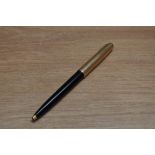 A Parker 65 ballpoint pen in black with rolled gold cap