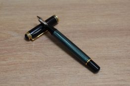 A Pelikan M600 piston fill fountain pen in green striped with black cap having Pelikan 18C 750 BB