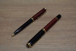 A Pelikan Souveran piston fill fountain pen and ballpoint pen in red and black striped pattern