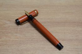 A Parker Duofold Special Lucky Curve button fill fountain pen in orange with raised band to the