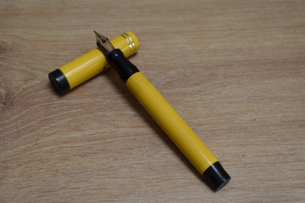 A Parker Duofold Senior Lucky Curve button fill fountain pen in mandarin yellow with two narrow