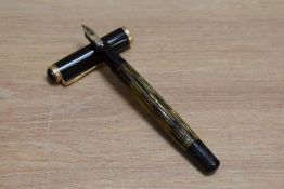 A Pelikan 400 piston fill fountain pen in tortoise shell striped with black cap having Pelikan 14C