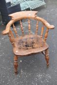 A late 19th or ealy 20th Century smokers bow armchair having elm seat