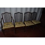 A set of four (three plus one) early 20th Century mahogany dining chairs having applique design rail