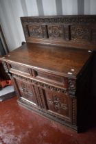 A period oak side cabinet having carved panel back , single drawer and double cupboards under, width