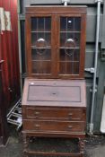 An early 20th Century oak bureau bookcase and a stand alone stained frame bookcase with leaded doors