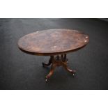 A 19th Century walnut breakfast table having inlaid oval top on quadruple turned column supports and