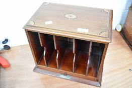 An Edwardian mahogany stationery rack with inlay to top and slide to base, with brass plaque '