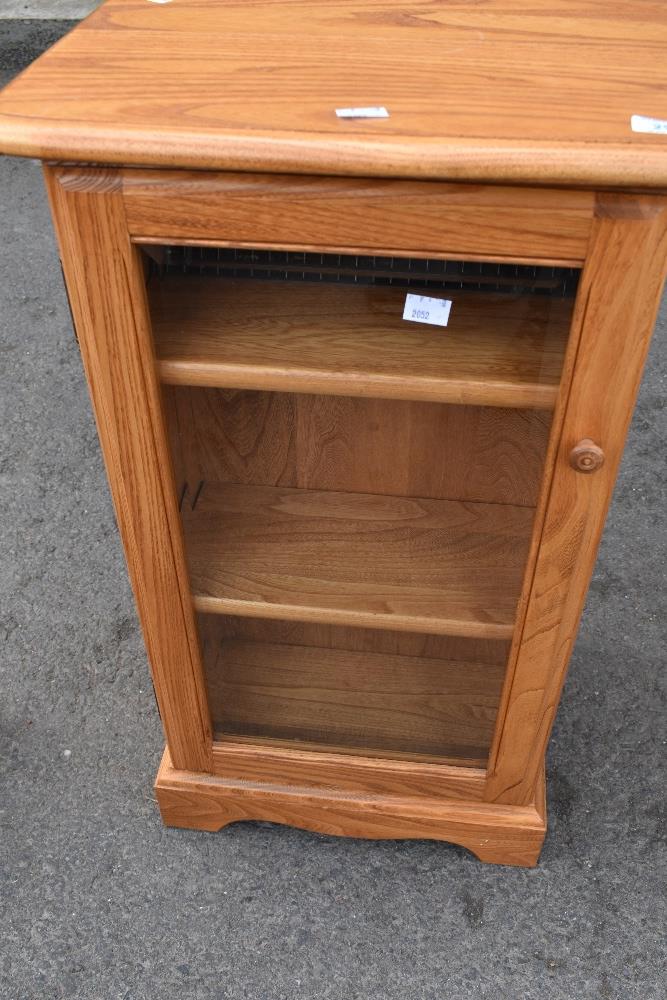 A modern Ercol display cabinet with shelves to side suitable for CDs etc