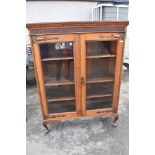 An Arts and Crafts oak bookcase with copper hinges, width 113 height 146cm