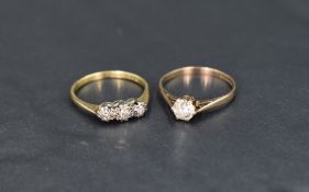 A diamond trilogy ring having three small stones in an illusionary setting on a yellow metal loop