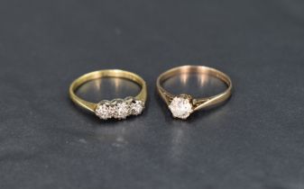 A diamond trilogy ring having three small stones in an illusionary setting on a yellow metal loop