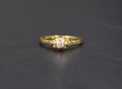 A diamond solitaire ring, the diamond set in a bezel illusion setting on a 18ct gold shank, ring