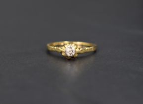 A diamond solitaire ring, the diamond set in a bezel illusion setting on a 18ct gold shank, ring