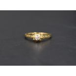 A diamond solitaire ring, the diamond set in a bezel illusion setting on a 18ct gold shank, ring