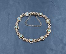 A Victorian 9ct rose gold bracelet having collet set opals in circular links with gold brick