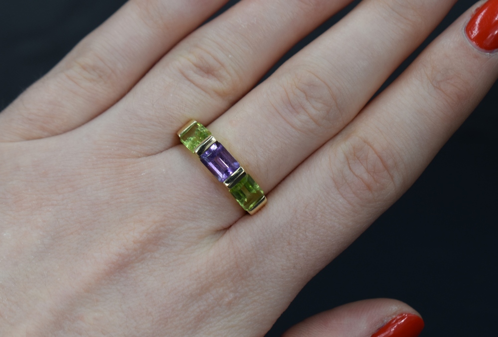A 9ct gold band ring having a central amethyst flanked by two peridots, size N & approx 3.2g - Bild 3 aus 3