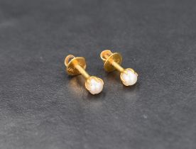 A pair of pearl stud earrings, the white pearls set in twenty-two carat gold with screw posts and