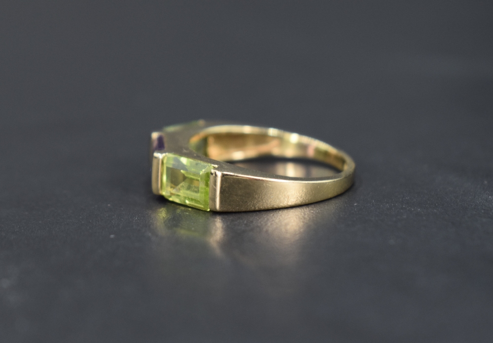 A 9ct gold band ring having a central amethyst flanked by two peridots, size N & approx 3.2g - Bild 2 aus 3