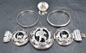 Four pieces of silver and white metal jewellery including two bangles, a Peruvian brooch in the form