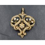 An Edwardian yellow metal brooch/pendant stamped 15ct having extensive seed pearl decoration, approx