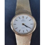 A ladies 9ct gold wristwatch by Omega, the champagne dial with baton five minute markers on a