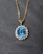 A blue gemstone (possibly blue topaz) and diamond 9ct gold cluster pendant, the oval cut blue