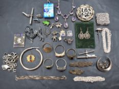 A selection of silver and white metal jewellery including charms, brooches, chains, rings, necklaces