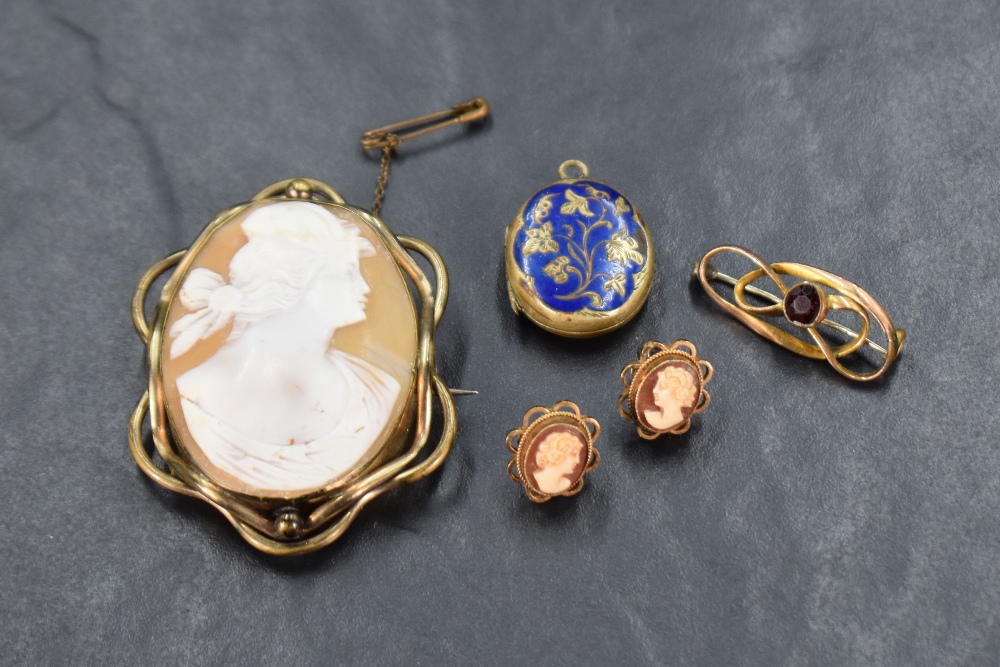 A conch shell cameo brooch depicting a maiden in profile in a pinchbeck mount with a pair of matched