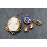 A conch shell cameo brooch depicting a maiden in profile in a pinchbeck mount with a pair of matched