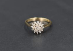 A diamond chip daisy cluster ring, total approx 0.035ct in a stepped claw setting on a 9ct gold
