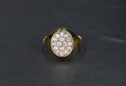 A gent's yellow metal signet ring having an oval panel set with 16 small diamonds total approx 0.